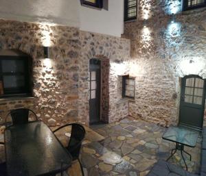 里托楚伦RiverBed Traditional Guest House的配有石墙、椅子和桌子的房间