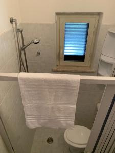 加埃塔Quirino Residence的一间带卫生间的浴室和一个带毛巾的窗户