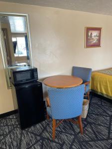 里弗顿Riverton Inn & Suites Riverton的配有桌子和两把椅子及一张床的房间