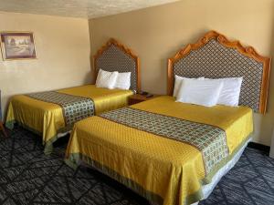 里弗顿Riverton Inn & Suites Riverton的酒店客房带两张带黄床单的床