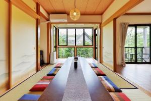 山中湖村湖の辺の宿時翠的客厅配有长桌和色彩缤纷的地毯