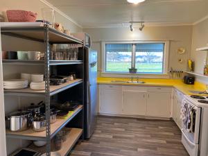 WairoaThe Cottage @ Aranui的厨房配有黄色柜台和冰箱。