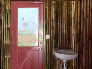Ban Pha Saeng LangBansuanphutarn的一间带水槽和红色门的浴室
