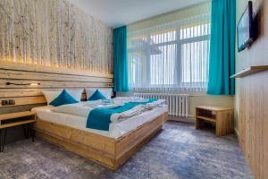 金特斯贝格Panorama Ferien Hotel Harz的一间卧室配有一张大床和电视