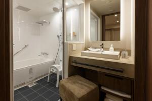 金泽Hotel Forza Kanazawa的一间带水槽、浴缸和镜子的浴室
