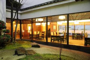 福冈福冈全日空皇冠广场酒店的一间设有玻璃门和桌椅的用餐室