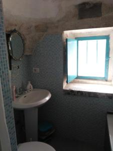 马丁纳弗兰卡Trullo Francisco的一间带水槽和卫生间的浴室以及窗户。