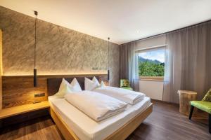 梅拉诺Ferienwohnung Pinot的一间卧室设有一张大床和一个窗户。