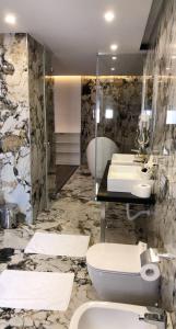 圣金HOTEL BAR RESTORANT YLLI的一间带两个盥洗盆和卫生间的浴室