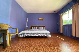 拉瑙OYO 90284 Kampung Stay Kilimu的蓝色卧室,配有床和椅子