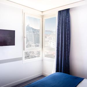 马赛快捷假日马赛圣查尔斯酒店的一间卧室设有窗户,享有城市美景