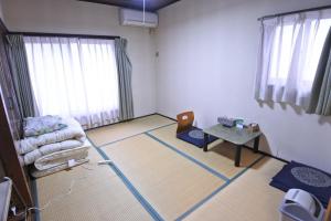 小山市Aikawa Ryokan - Vacation STAY 04180v的客房设有沙发、桌子和窗户。