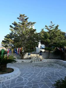 斯希努萨岛AGNADEMA Luxury Residences的一座建筑前方的带旗帜和树木的庭院