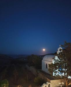 斯希努萨岛AGNADEMA Luxury Residences的夜晚的白色教堂,天空中满月