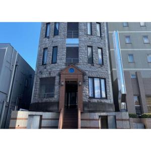佐贺市TAPSTAY HOTEL - Vacation STAY 35239v的前面有一扇门的高高的砖砌建筑