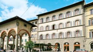 佛罗伦萨Palazzo dei Ciompi Suites的街道上有许多窗户的大建筑