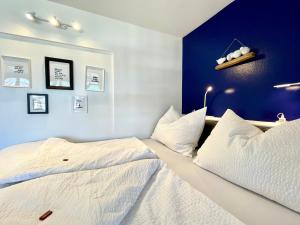 斯皮特安德劳Entzückende Garconniere im Herzen Spittals的卧室设有两张床铺和蓝色的墙壁