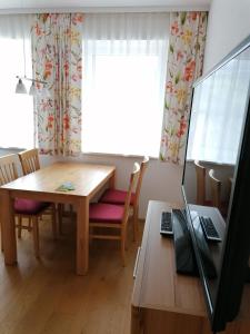 艾奇Appartement Alpenglück的用餐室配有桌子和笔记本电脑(书桌上)