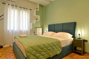 雅典Cozy Apt in Ilisia with Urban Forest View的一间卧室配有一张带绿毯的大床