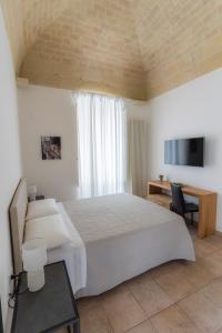 马泰拉Antica Pepice的卧室配有一张白色大床和电视。