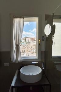 马泰拉Antica Pepice的浴室在窗户前设有大型白色浴缸