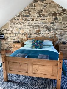 维尔Ash Tree的一间卧室配有一张木床和石墙