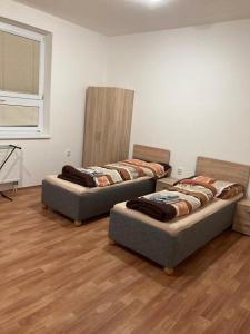 托普拉河畔弗拉诺夫Apartmanový byt v priemyselnej zóne的铺有木地板的客房内的三张床