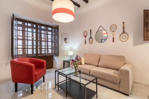 格拉纳达BnS Dauro Suites的带沙发和红色椅子的客厅