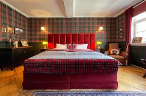 富尔达Boutique-Hotel Stadtvilla Hodes的一间卧室配有一张大床和红色床头板