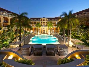 卡塔赫纳索菲特传奇圣克拉拉卡塔赫纳酒店的一个带棕榈树大型游泳池的度假酒店