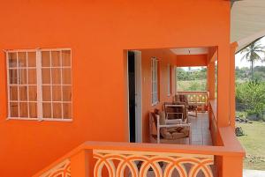 克朗角JGs Tropical Apartments的一座带橙色墙壁和阳台的房子