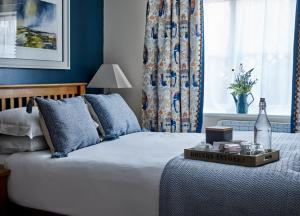 伊尔明斯特The Barrington Boar的一间卧室配有一张蓝色墙壁的床和一扇窗户