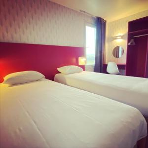 热尔扎克莱蒙费朗哲泽法斯特酒店的酒店客房设有两张床和窗户。