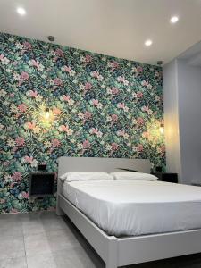 那不勒斯Terrazza Aragon Room and SPA的一间卧室配有一张带花卉壁纸的床