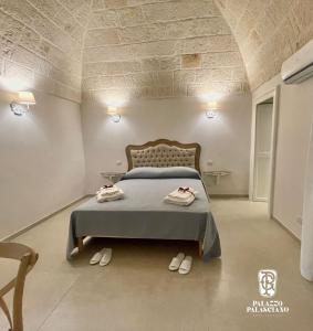 莫诺波利Palazzo Palasciano的一间卧室配有一张床,上面有两条毛巾