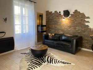 阿维尼翁My Pad Provence 7的客厅配有黑色真皮沙发和斑马地毯