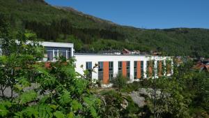 卑尔根卑尔根蒙大拿旅馆的白色的建筑,有橙色的窗户和山