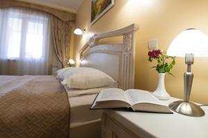 捷尔诺波尔捷尔诺波尔酒店的一间卧室配有一张带书籍和灯的床