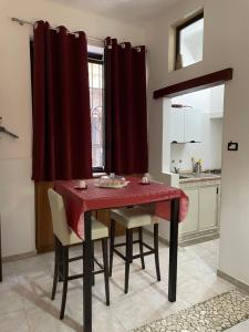 布林迪西Il vicoletto的一间用餐室,配有红色的桌子和椅子