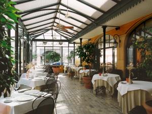 芒德法兰西酒店的餐厅配有带白色桌布的桌子