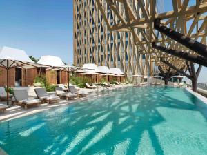 科威特科威特布尔阿沙哑四季酒店 的一座带椅子的大型游泳池和一座建筑