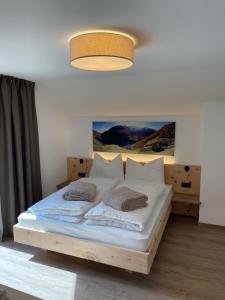塞纳莱斯Dorfblick Appartements & Rooms的一间卧室配有带白色床单和枕头的床。