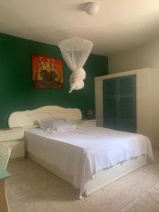 姆布尔Carthago的卧室配有白色的床和绿色的墙壁