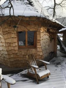 圣迪耶Parthénope - Les Cabanes du Chêne Rouvre的雪中带椅子的小木屋