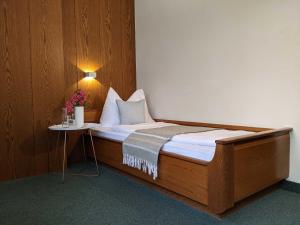 梅拉诺美泉宫酒店的一张床上的房间,上面有鲜花桌