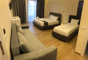 卡萨米尔Hotel Adriatik Ksamil的一间带两张床和一张沙发的客厅