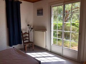 拉卡诺Cottage with a big idyllic garden at the lake的卧室设有窗户、一张床和椅子