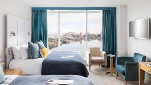 卡迪夫voco St. David's Cardiff, an IHG Hotel的酒店客房设有两张床和大窗户。