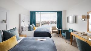 卡迪夫voco St. David's Cardiff, an IHG Hotel的酒店客房设有两张床和大窗户。