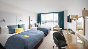 卡迪夫voco St. David's Cardiff, an IHG Hotel的酒店客房设有两张床和窗户。